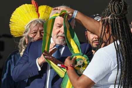 Aline Sousa coloca a faixa em Lula. Foto: Ricardo Stuckert